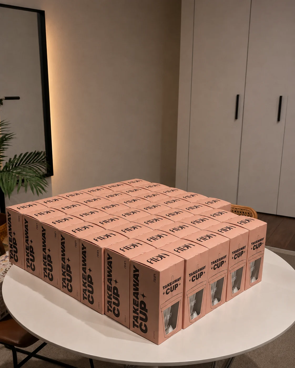 Peach Ada Studio takeaway cup packaging arranged on a round table